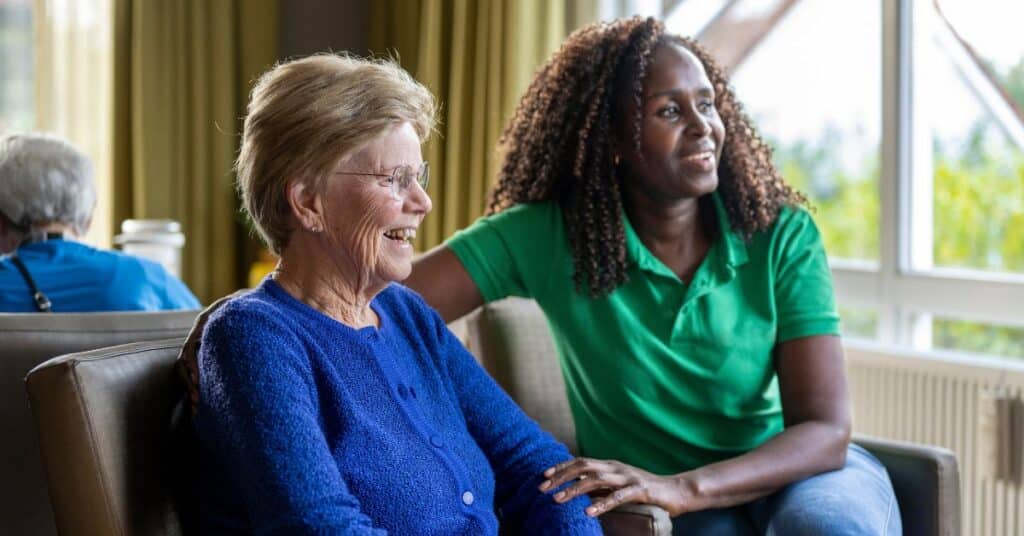 How Daily Routines Support Dementia Care: A Family Guide 1 Happy Senior Resident In Dementia Care With Nurse