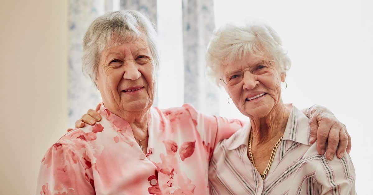Assisted Living: The Honest Pros And Cons You Need To Know 1 Two-Happy-Senior-Residents-In-Assisted-Living-Hugging-Each-Other